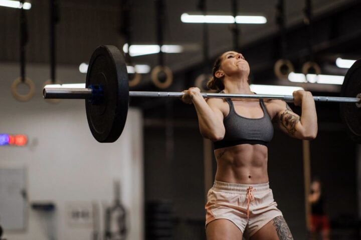 A woman completing a CrossFit workout with a barbell