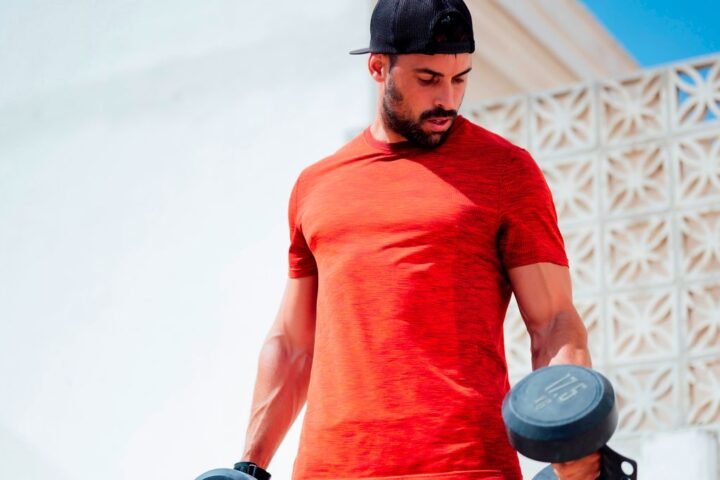 Muscular man holding heavy dumbbells